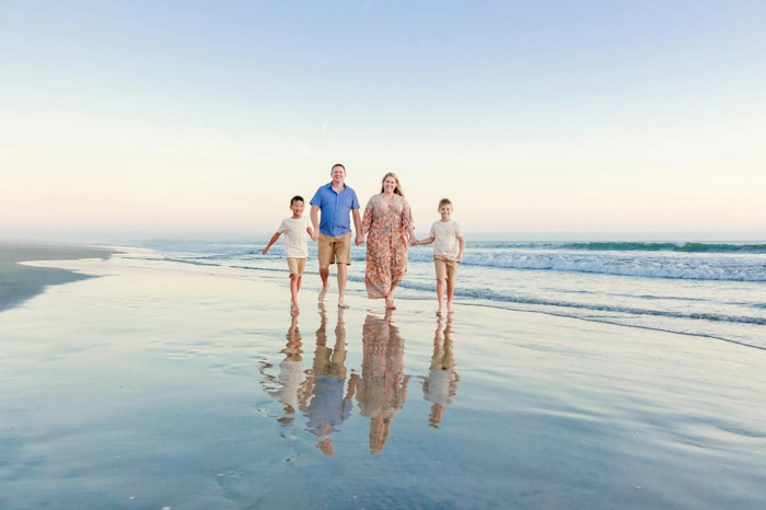 Family walking on a San Diego beach at sunset