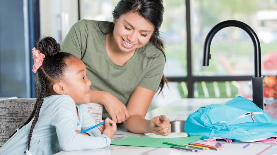 Babysitter and little girl smiling in the kitchen