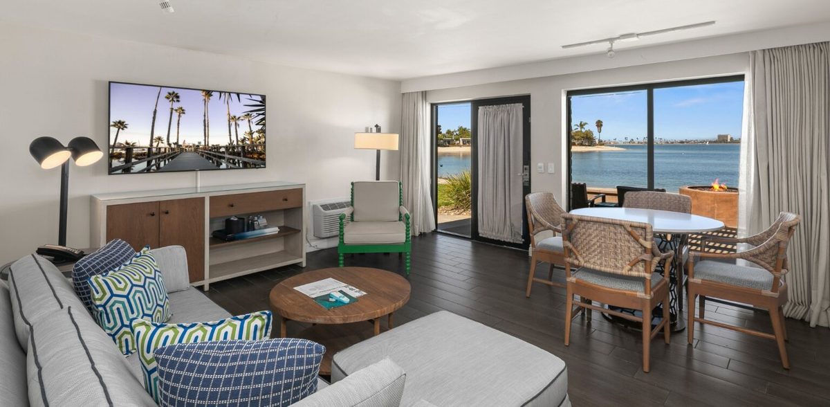 Paradise Point Resort bayside bungalow suite living room with Mission Bay views, patio fire pit, and coastal decor