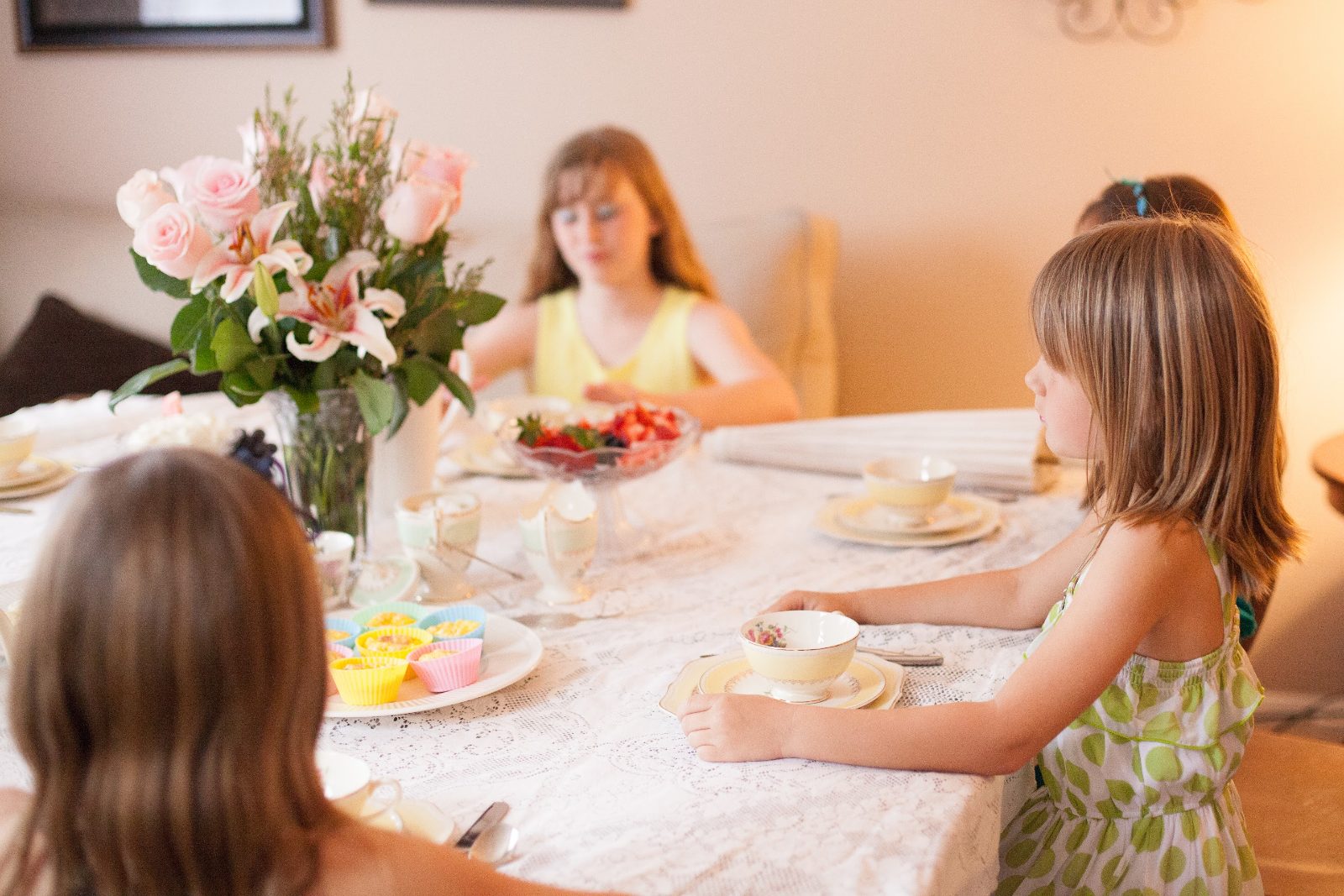 Kids enjoy a San Diego high tea with flowers and strawberries at the table